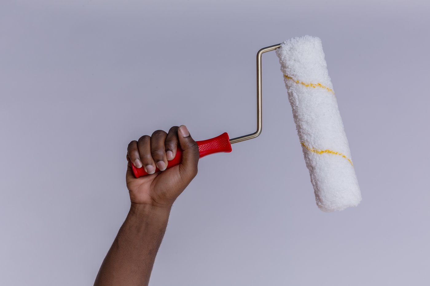 Hand holding a Dizat paint roller, ready to apply a fresh coat