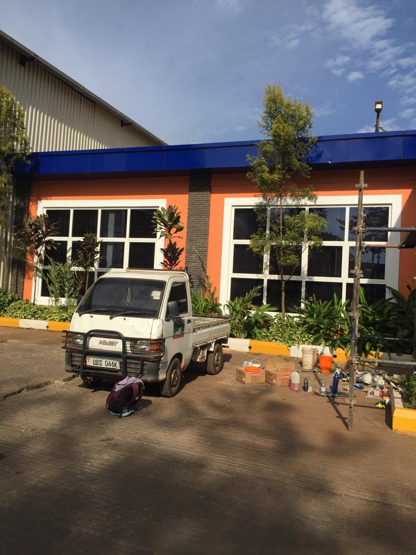 Uganda Baati showroom exterior finished in orange and white, delivery vehicle parked outside