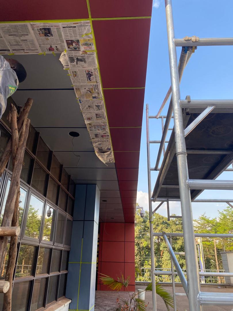 Newspaper and tape masking along a canopy edge in preparation for spray painting