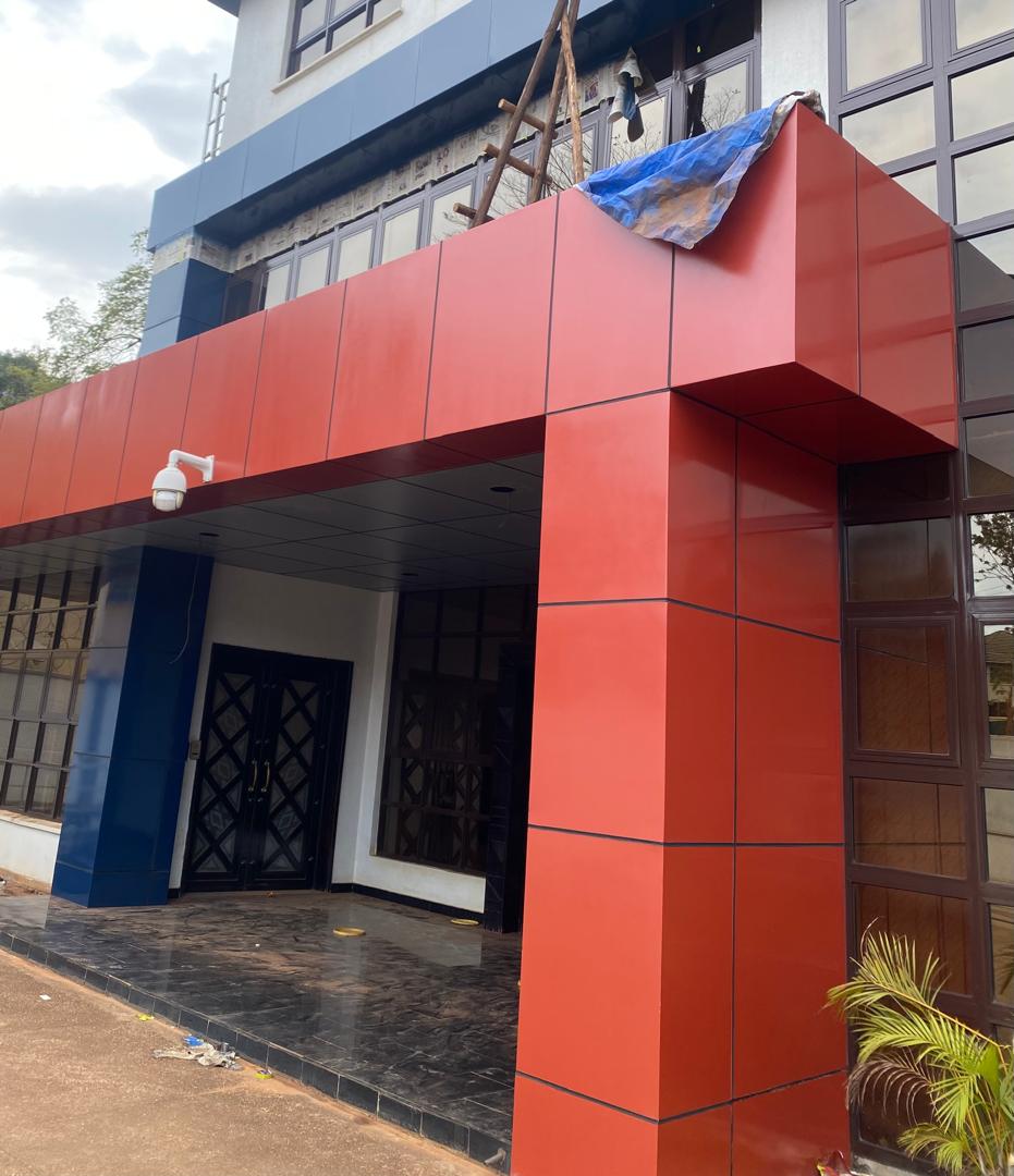 Corner view of a maroon commercial entrance canopy after cladding repaint