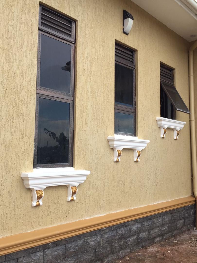 Row of louvre windows finished with white and gold corbel brackets on a bungalow exterior