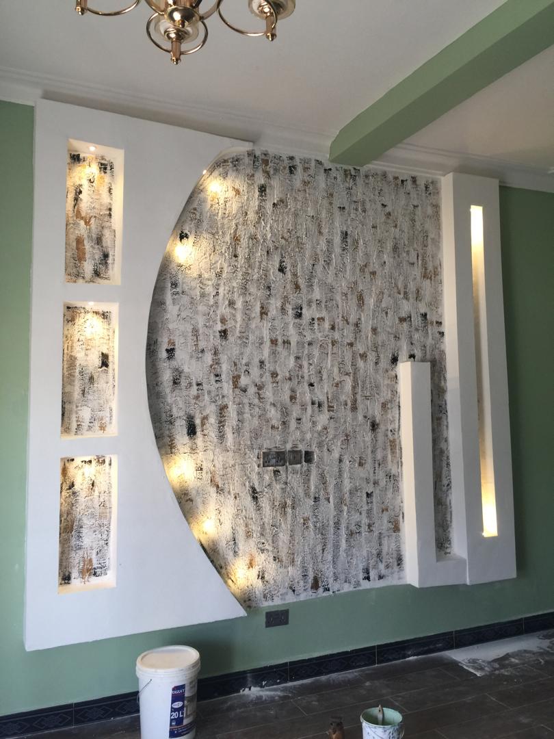 Sage green living room with a curved textured feature wall and recessed lighting niches