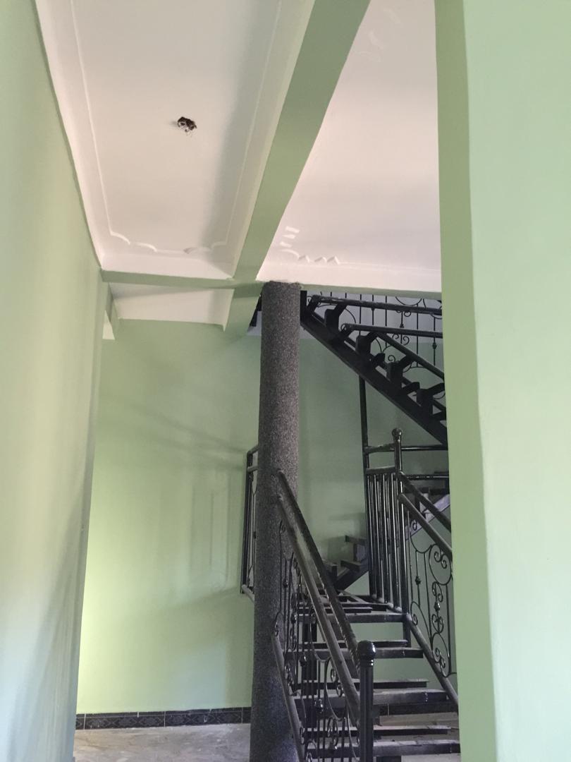 Interior stairwell finished in sage green with black wrought iron balustrade