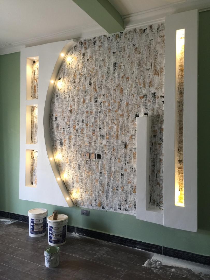 Curved gypsum feature wall with textured stone-effect finish and integrated lighting